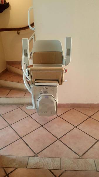 Monte-escalier courbe avec assise, accoudoirs et repose pieds repliés