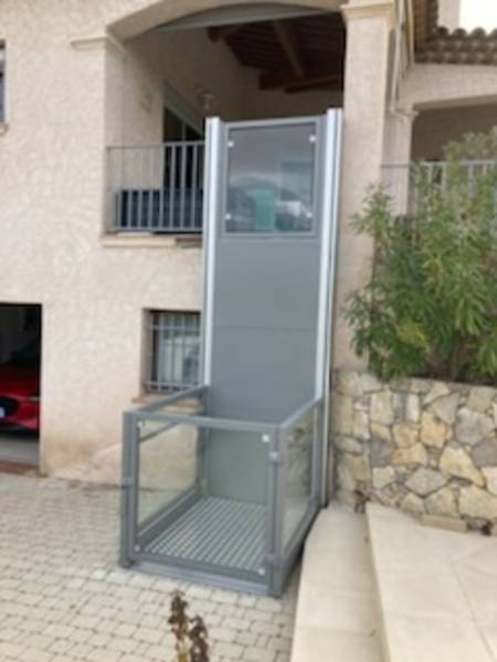 Elévateur SIGMA  avec nacelle en bas et vue sur le portillon en haut